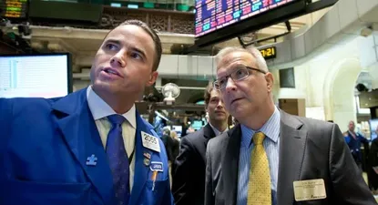 El comisario de Economía europeo Olli Rehn, a la derecha, en la bolsa de Nueva York