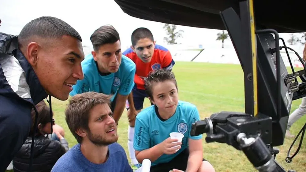 El protagonista, Facundo Campelo, y extras observan el playback de una escena recién grabada