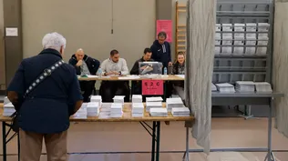 Un hombre escoge papeleta para ejercer su derecho al voto en un colegio electoral en Durango, Bizkaia, este domingo.