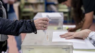 Una persona mete su voto en la urna en un colegio electoral, a 28 de mayo de 2023, en Madrid (España). 