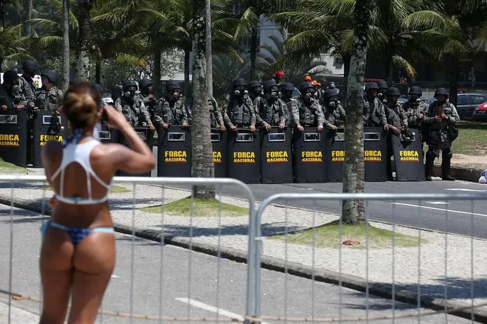 Brasil- Una mujer en traje de baño toma fotografías a la Fuerza Nacional de Seguridad en Río de Janeiro