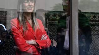 Begoña Gómez y, en el reflejo del vidrio, Pedro Sánchez