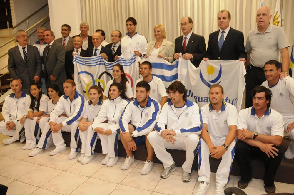 Los atletas reciben el pabellón de las autoridades del deporte uruguayo