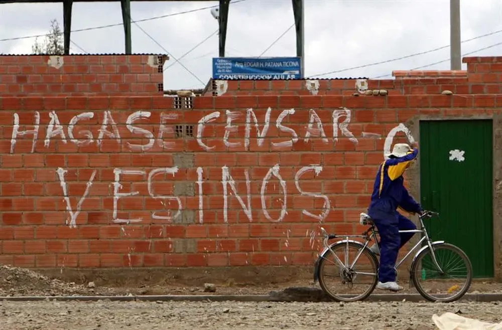 Bolivia- Un ciudadano pasa frente a un muro pintado con motivo del censo poblacional