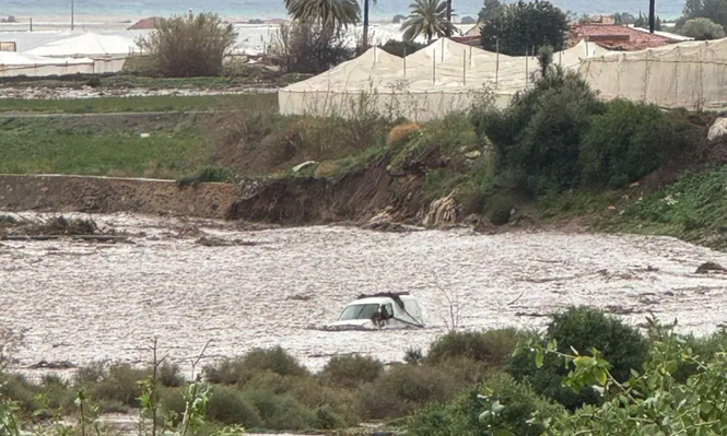 La rambla desbordada arrastra un vehículo en Lorca, Murcia.
