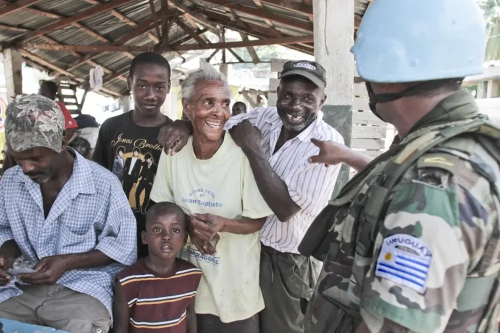 Un soldado uruguayo bromea en diaelcto creole con comerciantes de un mercado en puerto Jeremie, al sur de Haití.