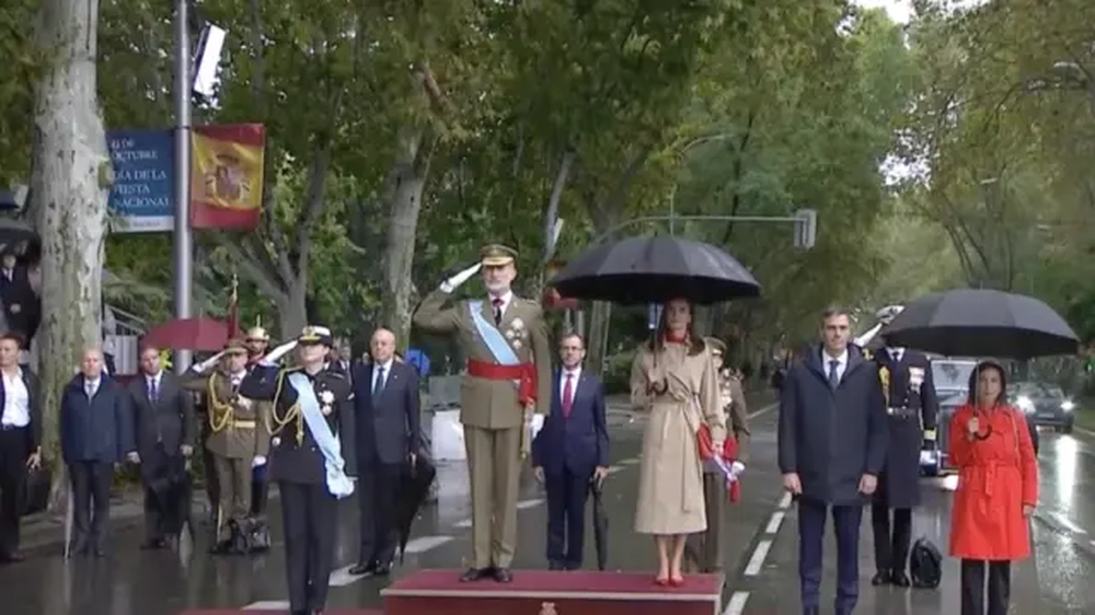 El Rey Felipe VI, la reina Letizia y la princesa Leonor, bajo la lluvia en el comienzo del desfile por el Día de la Hispanidad.