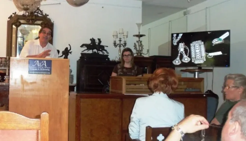 El rematador Ernesto Prilassnig subastando alhajas en la subasta de joyas, relojes y monedas