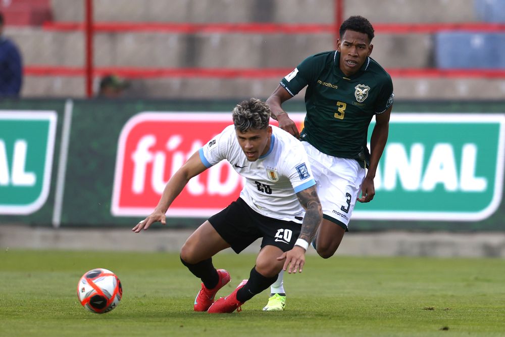 Diego Román de Bolivia disputa un balón con Maximiliano Araújo de Uruguay por Eliminatorias