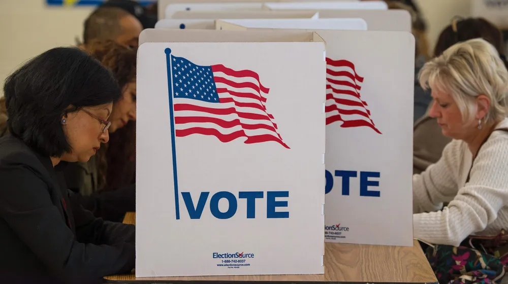 People cast their votes for US president and local politics November 8, 2016, at Colin Powwell Elementary School, in Centreville, Virginia. Polling stations opened Tuesday as the first ballots were cast in the long-awaited election pitting Hillary Clinton against Donald Trump. / AFP / PAUL J. RICHARDS
