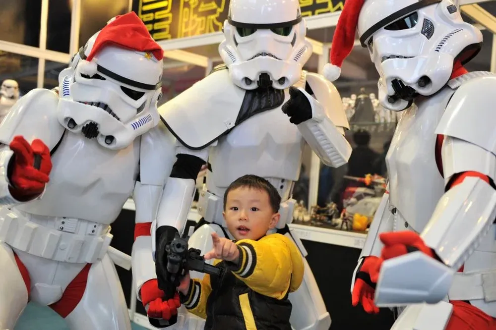 Fans de Star Wars disfrazados de stormtroopers posan con un niño durante una exhibición de juguetes en Taipei, Taiwán