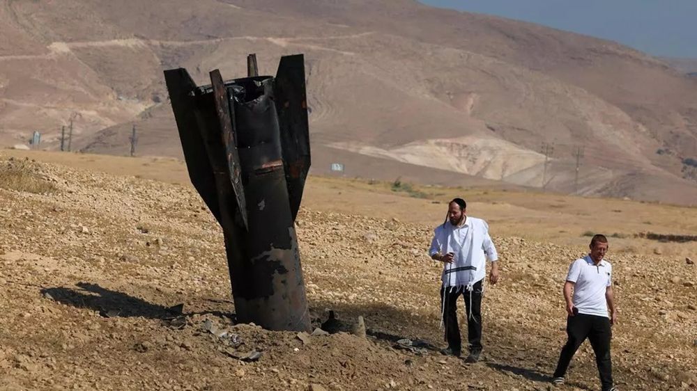 Jericó, 8 de junio de 2026. Dos hombres examinan un cohete caído y semienterrado en las afueras de Jericó tras ataques iraníes y de rebeldes hutíes respaldados por Irán. AFP