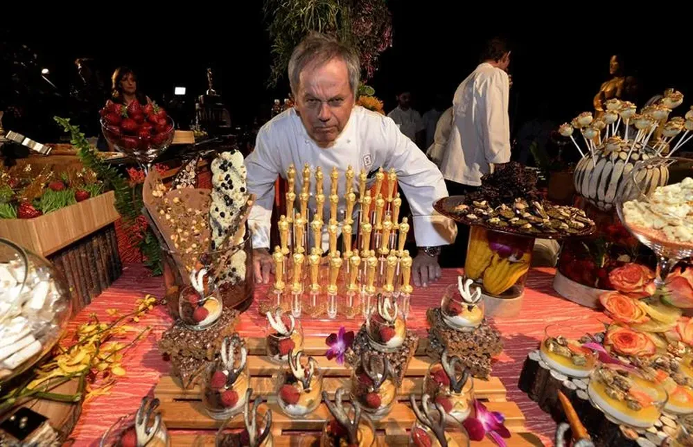 El chef austriaco Wolfgang Puck posa junto a las estatuillas de chocolate