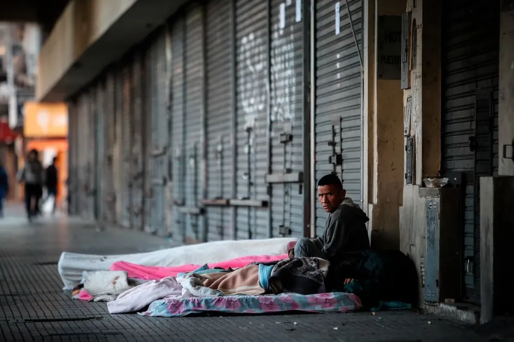 Un hombre en situación de calle permanece frente a la estación de tren Once, en Buenos Aires