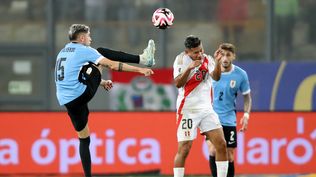 Edison Flores de Perú disputa un balón con Federico Valverde de Uruguay   