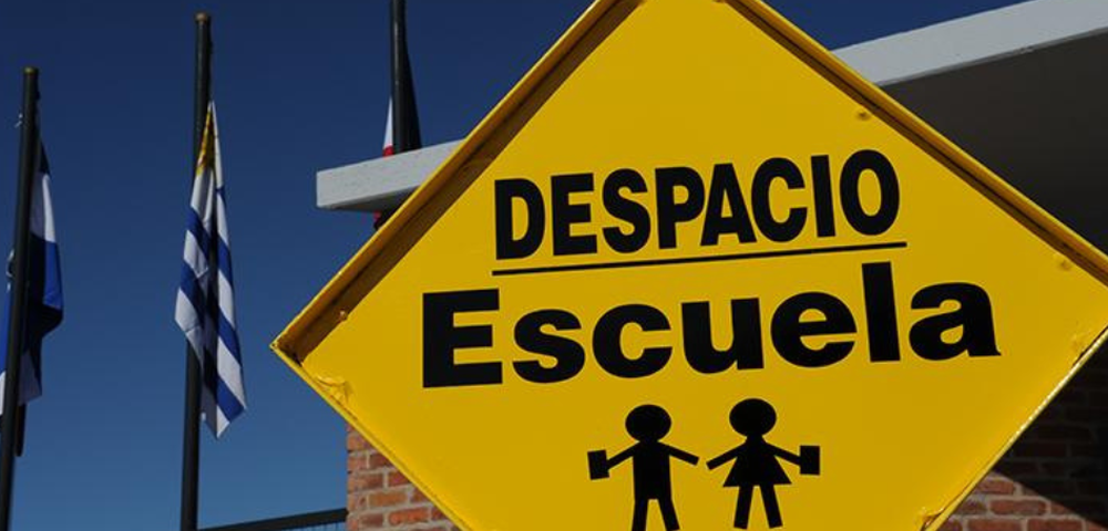 Cartel de precaución por velocidad en centros educativos