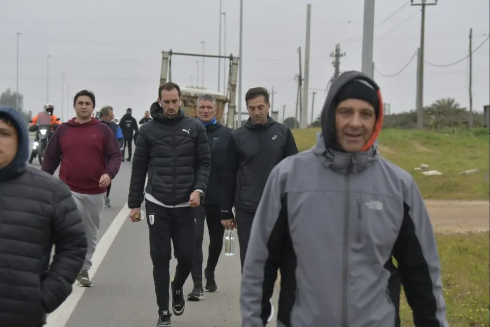 Diego Godín, Diego Alonso y atrás Carlos Nicola, durante la caminata hacia el Complejo de la AUF