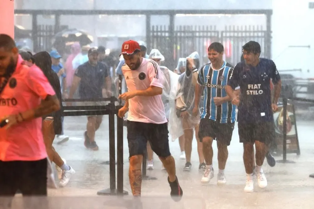 Hinchas bajo la lluvia esperando la presentación de Messi