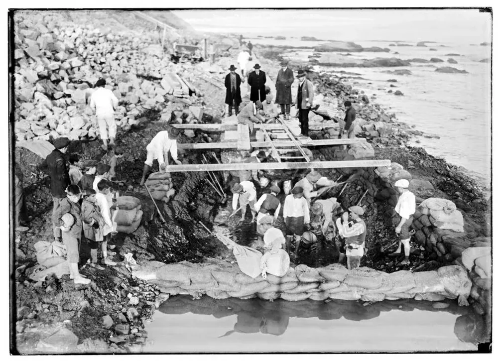 En la fotografía se ve a un grupo de trabajadores en plena obra. De acuerdo al Centro de Fotografía de Montevideo, la Rambla Sur modificó la geografía natural de la costa y posibilitó la afluencia y apropiación de ese espacio por parte de la población de la ciudad.