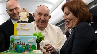 El papa Francisco cuando celebró sus 88 años con la torta que le regalaron periodistas en el avión de regreso de su viaje a Córcega