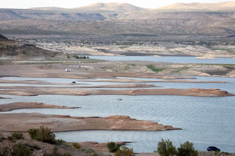 Vehículos estacionan en tierra próximo a un lago que se seca debido a las altas temperaturas en Nuevo México, Estados Unidos