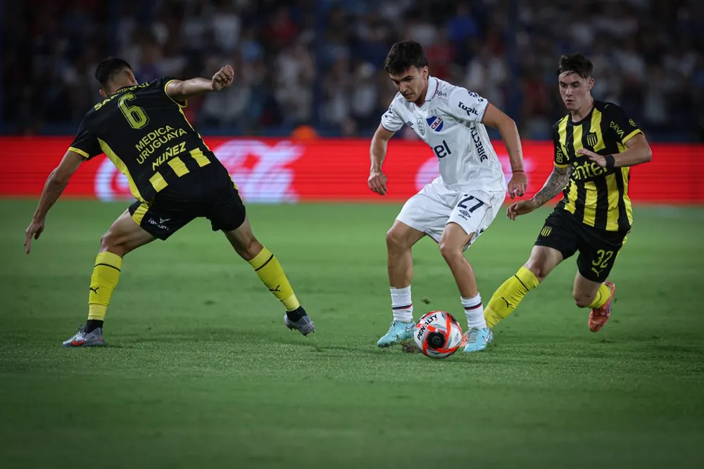 Tomás Verón Lupi de Nacional ante Leandro Umpiérrez y Lucas Ferreira de Peñarol por el Torneo Apertura