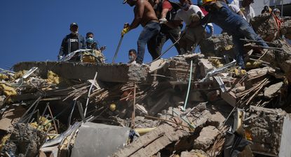 Personas trabajan en labores de rescate en una edificación colapsada por el terremoto de magnitud 7,4 que sacudió al país este lunes, en Cali (Colombia).