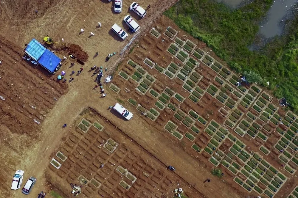 Operarios quemando los cuerpos de las víctimas de coronavirus en Indonesia