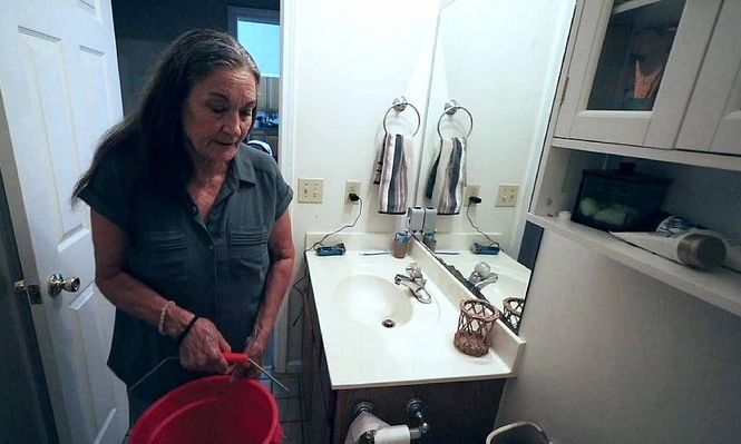 Beverly Morris tiene que llenar baldes para el inodoro debido a la baja presión del agua.