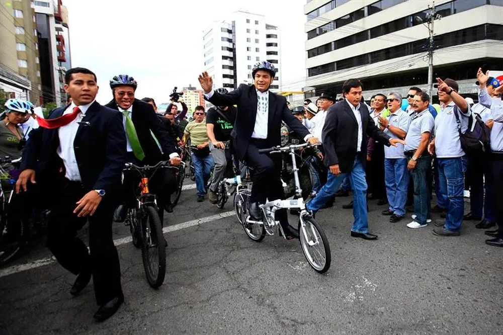 Ecuador- Rafael Correa anda en bicicleta y saluda simpatizantes el día que anunció que va por la reelección