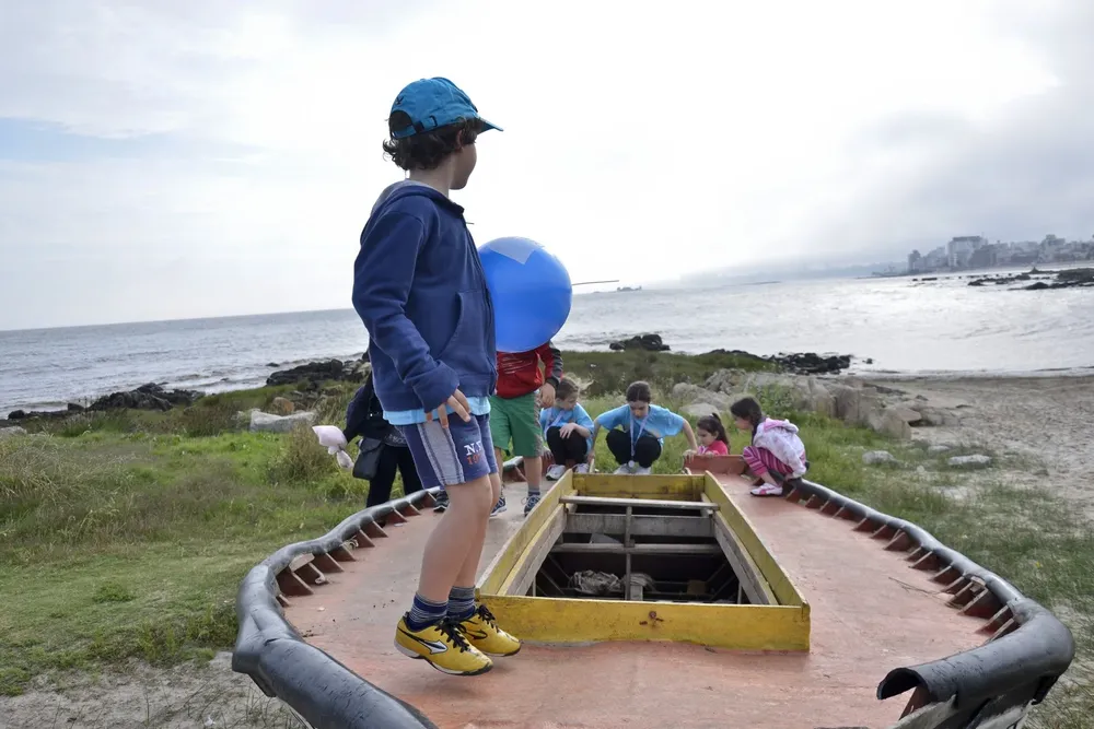 Sábado 9. Un grupo de niños juega con un bote en la playa de los Ingleses