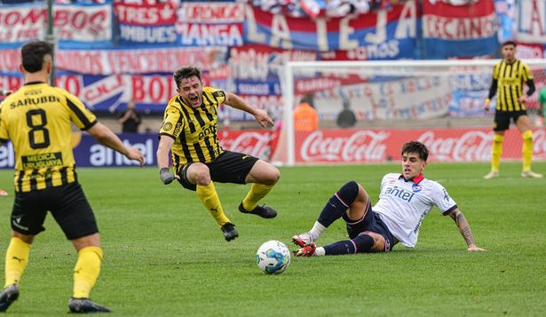 Lucas Hernández de Peñarol recibe una fuerte falta de Alexis Castro de Nacional en la final del Torneo Intermedio