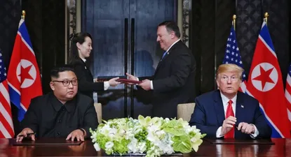 This handout photo taken on June 12, 2018 and released by The Straits Times shows US President Donald Trump (R) and North Koreas leader Kim Jong Un (L) looking on as documents are exchanged between US Secretary of State Mike Pompeo (2nd R) and the North Korean leaders sister Kim Yo Jong (2nd L) at a signing ceremony during their historic US-North Korea summit, at the Capella Hotel on Sentosa island in Singapore. Donald Trump and Kim Jong Un became on June 12 the first sitting US and North Korean leaders to meet, shake hands and negotiate to end a decades-old nuclear stand-off.Kevin LIM / THE STRAITS TIMES / AFP