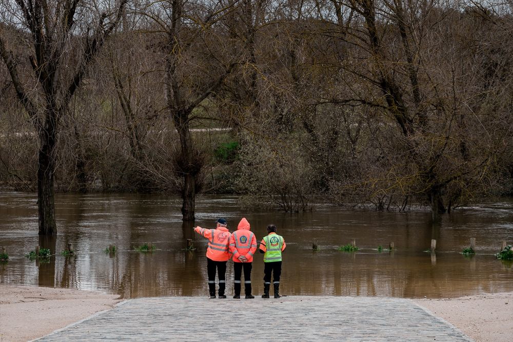 Tres agentes del SAMUR observan el parking de Somontes inundado, en Madrid. EUROPA PRESS