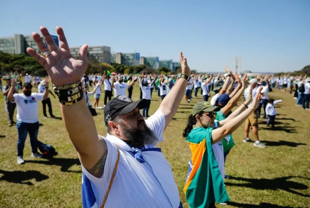 Manifestantes rezando en el acto de reivindicación de las armas