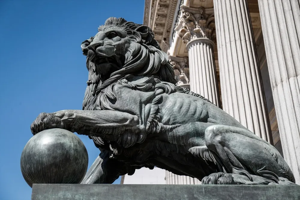 Uno de los emblemáticos leones que se encuentran delante de la fachada del Congreso de los Diputados en la Plaza de las Cortes de Madrid.(Archivo)
