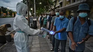 Un trabajador desinfecta a personas que viven en las calles de Bangkok para prevenir el crecimiento de los contagios de coronavirus