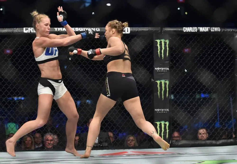 Holly Holms (blanco) contra Ronda Rousey (negro)
