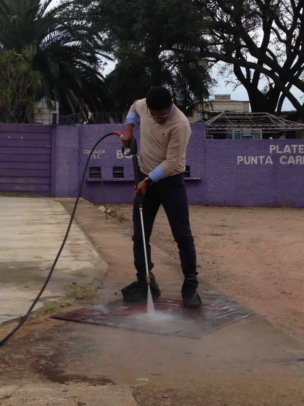 El ex jugador de fútbol, Nicolás Olivera, coloca un afiche en el Estadio Franzini.