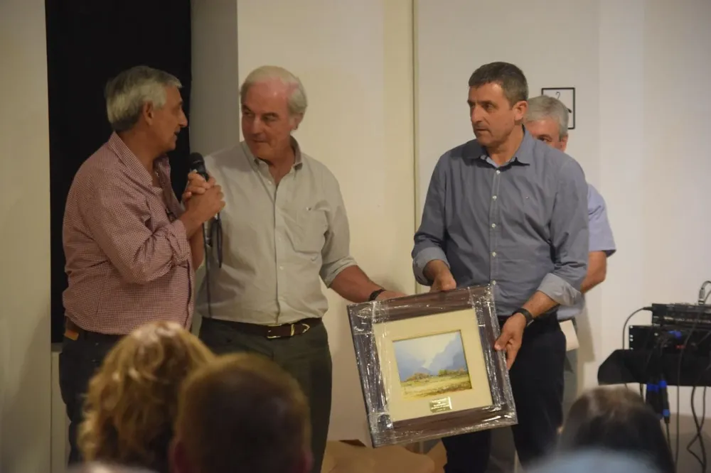 Gabriel Fernández Secco y Alejandro Pérez Viazzi entregan un reconocimiento a Álvaro Ambrois.