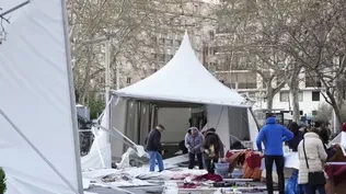 Varias personas recogen piezas del suelo tras volarse las carpas ubicadas en la Feria de la Artesanía de Valladolid