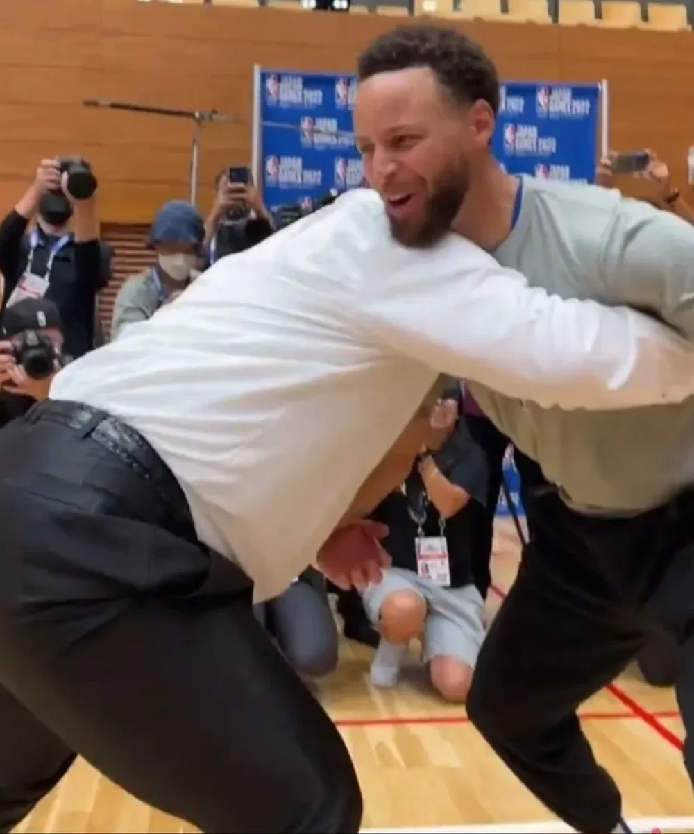 Stephen Curry tratando de mover a un luchador de sumo