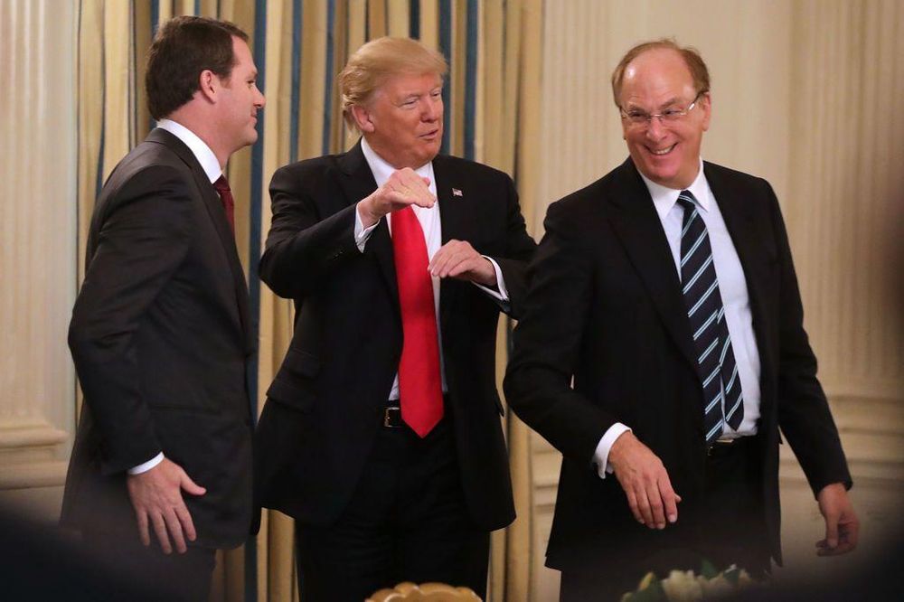 Trump junto a los directores ejecutivos de Walmart, Doug McMillon (a la izquierda) y de BlackRock, Larry Fink, a la derecha, en 2017.