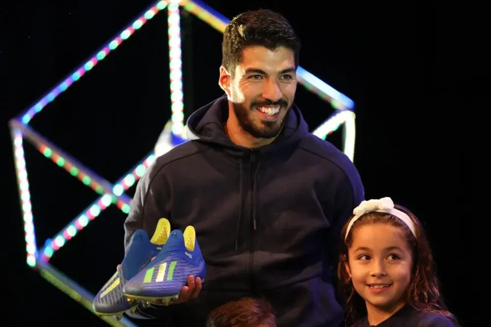 Suárez junto a su hija Delfina y sus Adidas para el Mundial