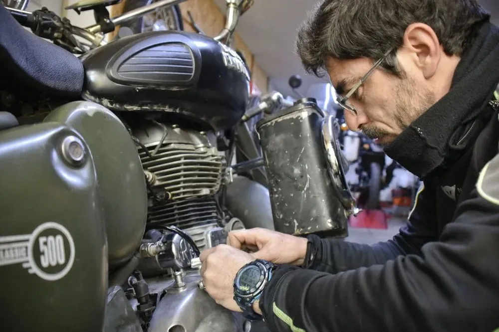 Astrada con su moto en Montevideo, donde la está ajustando para continuar su viaje