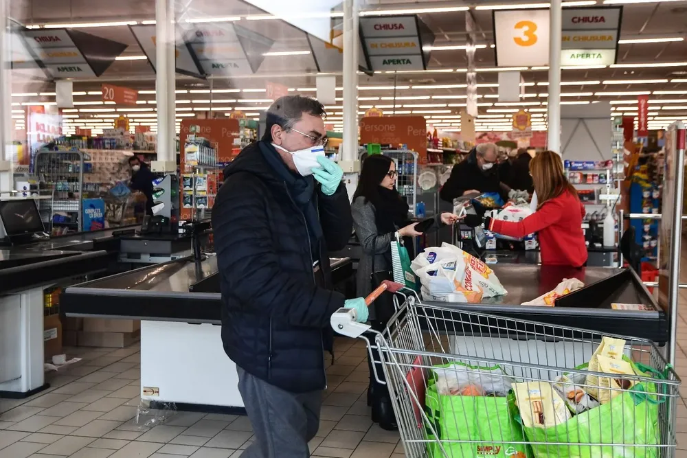 En Codogno, la ciudad donde está el foco principal del virus, hay fila para entrar a un supermercado.