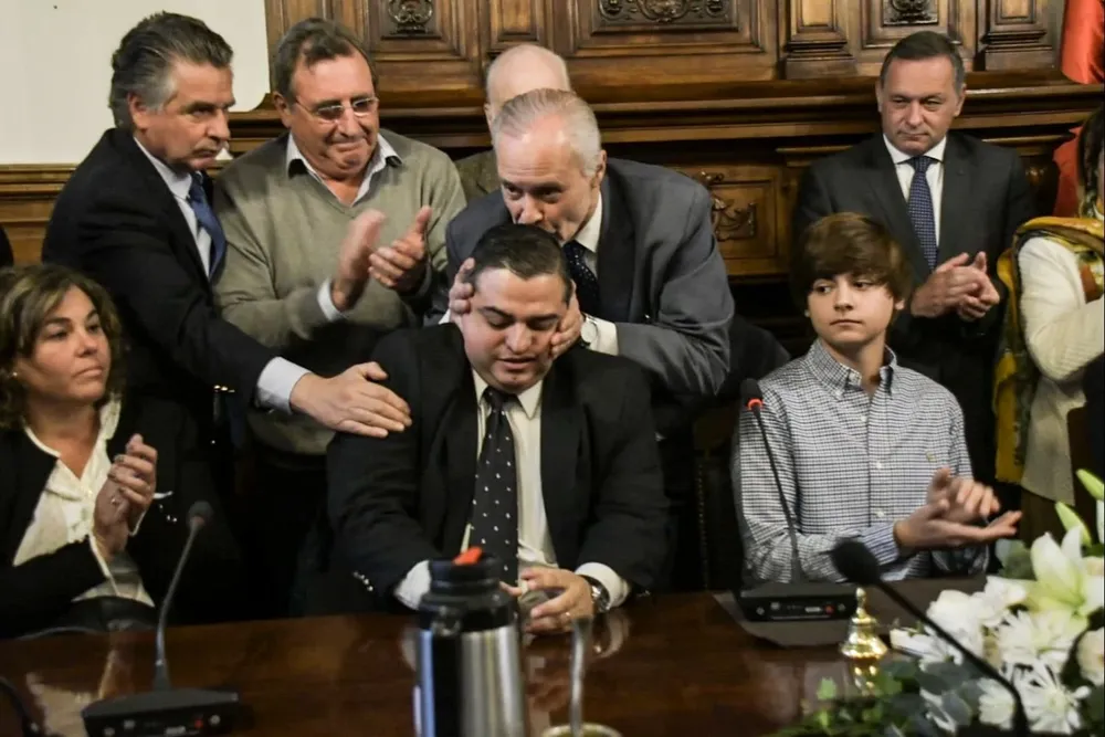 El presidente del directorio le da un beso al director general de Secretaría del Ministerio del Interior, Luis Calabria,