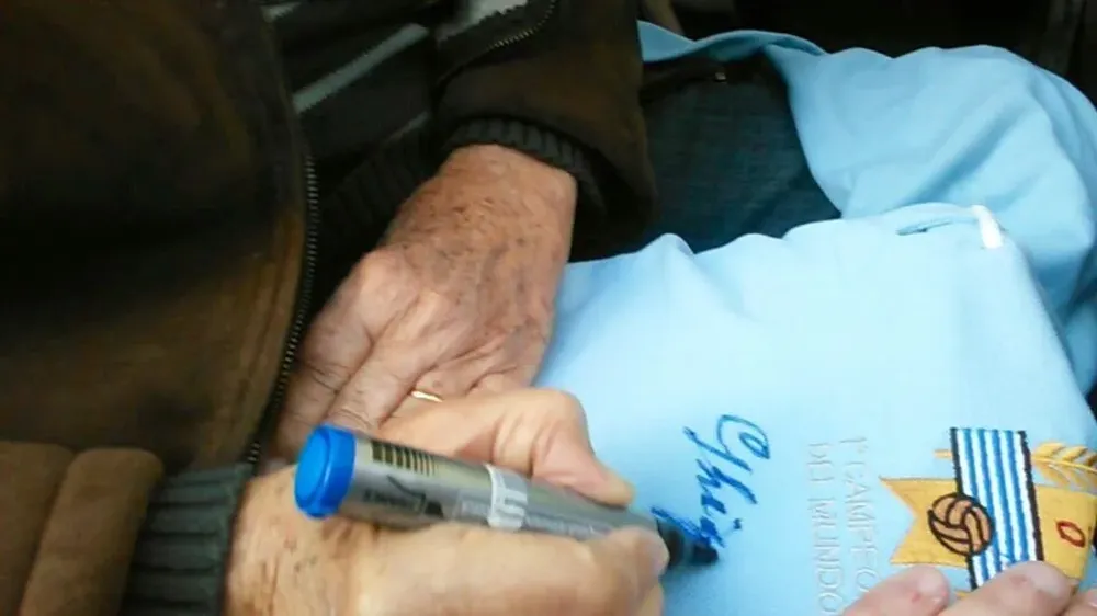 Ghiggia firmando la camiseta celeste