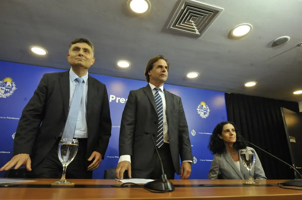 El director de OPP, Isaac Alfie, y la ministra de Economía, Azucena Arbeleche, rodean al presidente Luis Lacalle Pou en una conferencia de prensa en marzo de este año