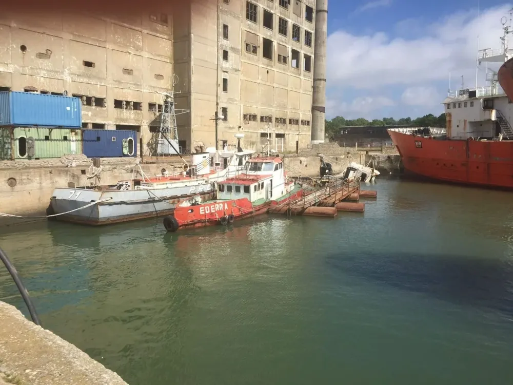 Las tres embarcaciones que hundieron en la Armada. La más chica, la naranja, es la Enderra. Contra el muelle, gris, la ROU 71. Y la Rou 70 está semihundida contra el muelle, más atrás